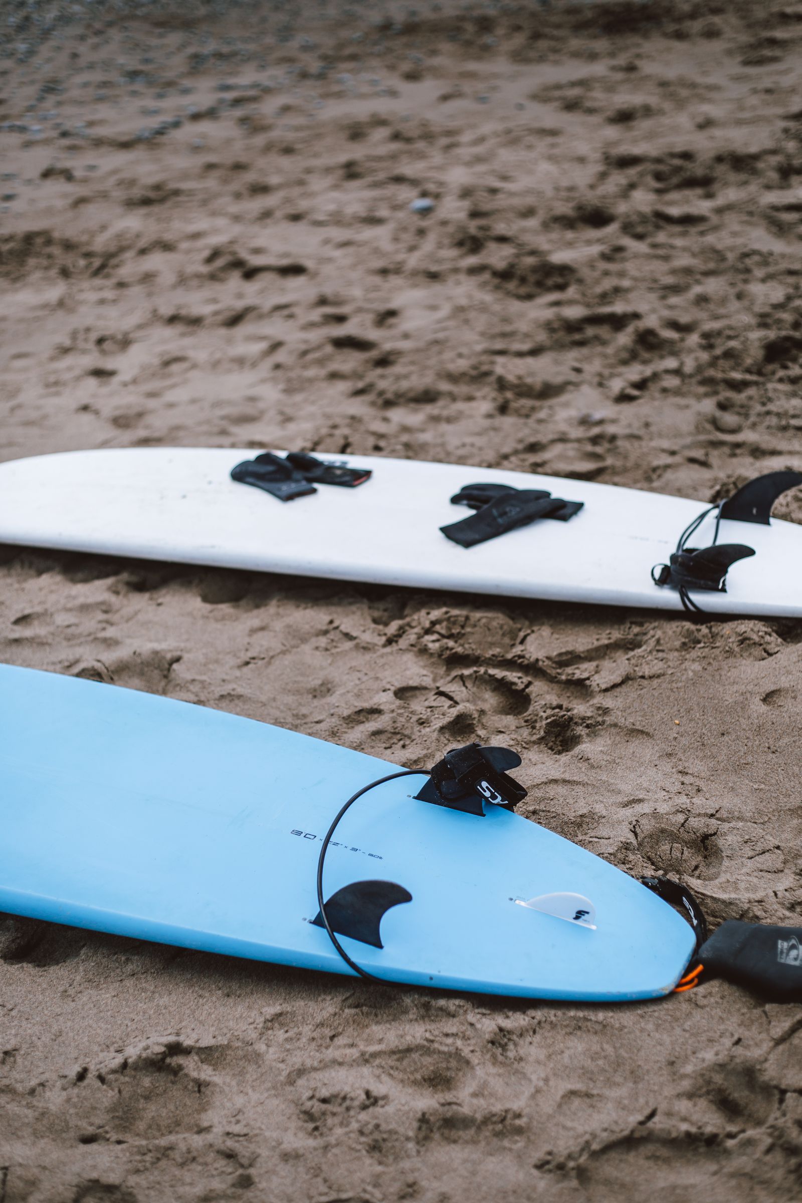 Two surfboards resting on the sand at Santa Teresa, ready to rent from Armonia